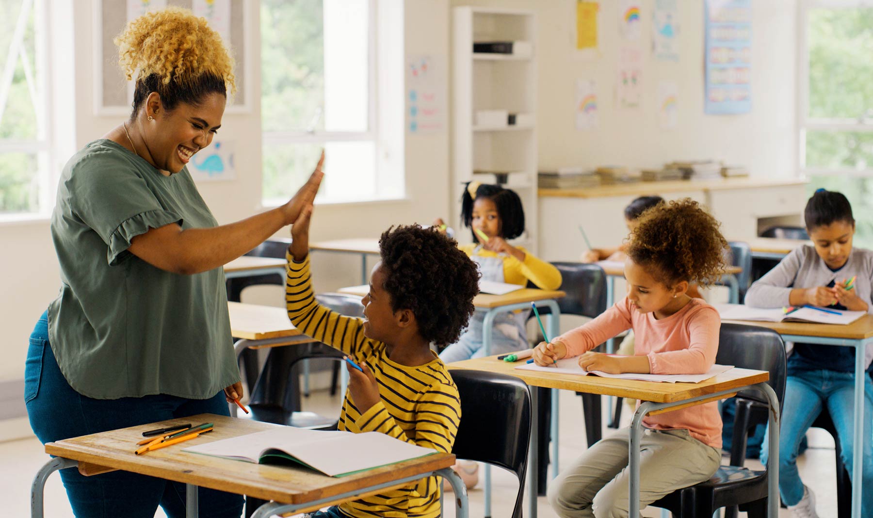 Happy teacher in classroom with children